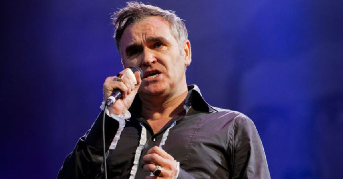 Morrissey’s Last-Minute Stockholm Concert Cancellation Sparks Fan Outrage and Industry Debate Legendary British singer Morrissey canceled his highly anticipated concert at Stockholm’s Hovet Arena on Monday, June 23, just hours before the show. This sudden announcement upset thousands of fans who were ready for what they expected to be a memorable night with the former frontman of The Smiths. Morrissey’s team said the cancellation was due to exhaustion among the band and crew. The 66-year-old artist, who is currently touring Europe, mentioned that they had traveled through six countries in just one week. “We are travel-weary beyond belief,” he said, highlighting the physical and emotional strain of constant touring. Besides exhaustion, Morrissey also complained about the lack of support from the music industry. He pointed out that he does not receive enough financial help from record labels, which he believes is necessary for artists to reach fans in cities like Stockholm, Reykjavik, and Helsinki. Even with strong ticket sales and loyal fans, Morrissey feels frustrated that no labels want to release his music or support his tours, and he also struggles with limited radio airplay. Fans who bought tickets for the Stockholm show were informed about the cancellation and were told they could get refunds at the point of purchase. The quick announcement led to criticism, with many longtime fans expressing their disappointment over Morrissey’s growing number of last-minute cancellations on his recent tours. This cancellation adds to the ongoing tensions between Morrissey and the music industry. His long-delayed album, Bonfire of Teenagers, remains unreleased due to disputes with record labels. This situation highlights the gap between Morrissey’s lasting popularity and the industry’s unwillingness to support his work. Despite this issue, Morrissey plans to continue his tour, with the next performance scheduled in Berlin on June 27. As fans in Scandinavia deal with this disappointment, the situation has sparked discussions about artist welfare, industry responsibility, and the difficulties faced by older musicians in today’s changing music scene. For now, Morrissey’s supporters hope he will recover and return to the stage, while the music industry pays attention to his request for better support and recognition.